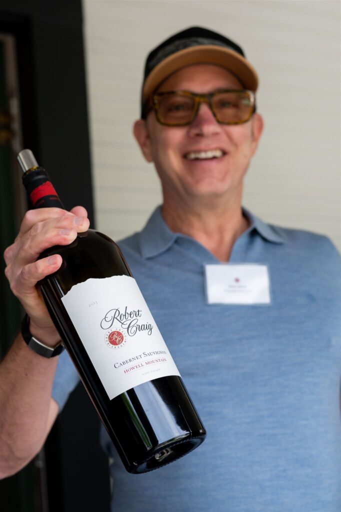 Spring Soiree Event at Robert Craig - Elton Slone holding wine bottle